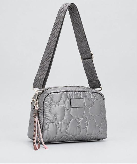 A silver quilted shoulder bag with a matching patterned strap