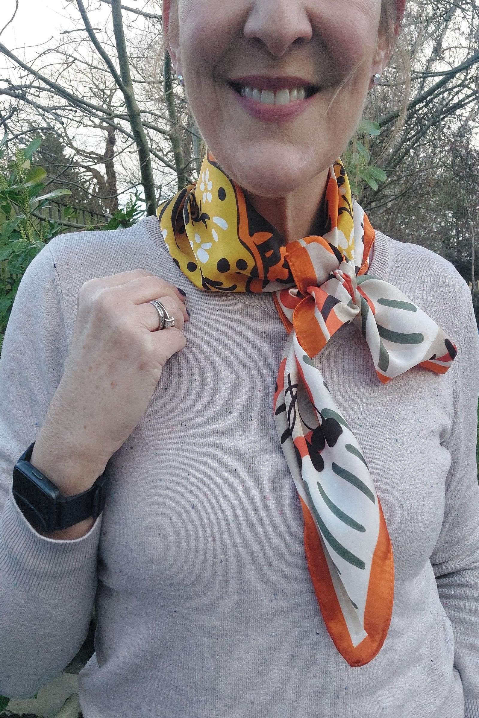 Person wearing a colorful scarf with a forest background